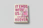 Book titled 'It Ends with Us' by Colleen Hoover on a wooden surface